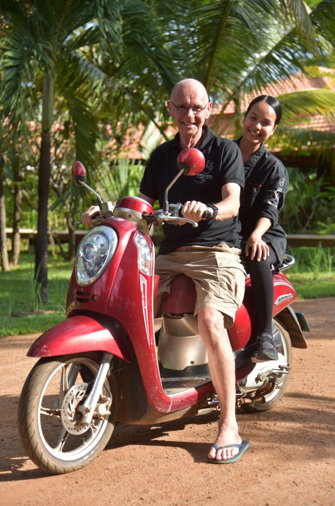 Hannes Schmidt mit einer asiatischen Frau auf einem roten roller